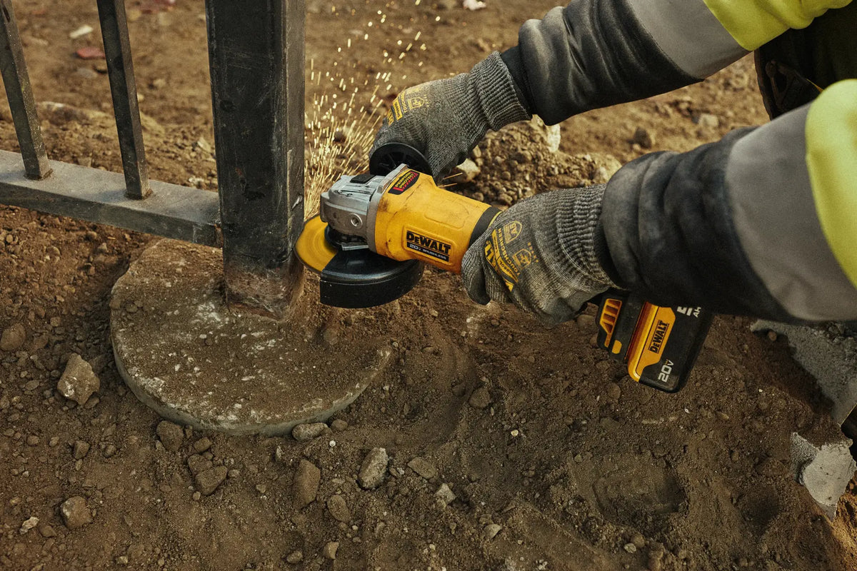 DEWALT DCG408P2-B3 en uso, desbaste de poste metálico