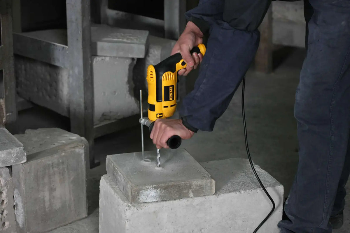 Taladro DEWALT DWD024-B3 en uso sobre bloque de concreto en obra
