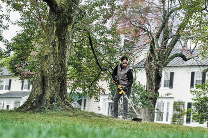 DEWALT DCST922P1 en uso, corte de césped alrededor de árbol