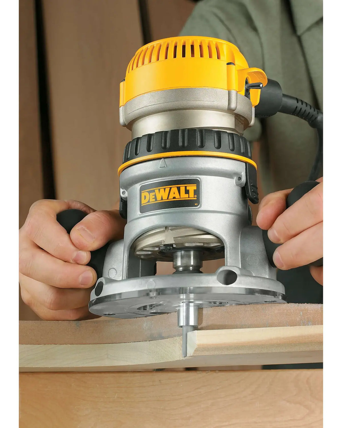 DEWALT DW616 dando forma al borde de una pieza de madera, vista de cerca