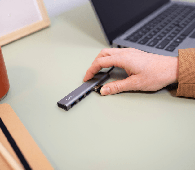 Hub USB-C Trust Halyx conectado a laptop con cable USB-C
